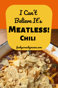 Pinterest image for "I Can't  believe it's meatless!" chili. It shows a bowl of meatless chili covered in tortilla chips  on an orange background. 