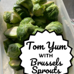 Pinterest image. Image shows a bowl of fresh Brussels sprouts with the title "tom yum with Brussels sprouts" in a medallion shape.