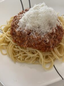 A plate full of spaghetti covered in a meatless sauce and parmesan.